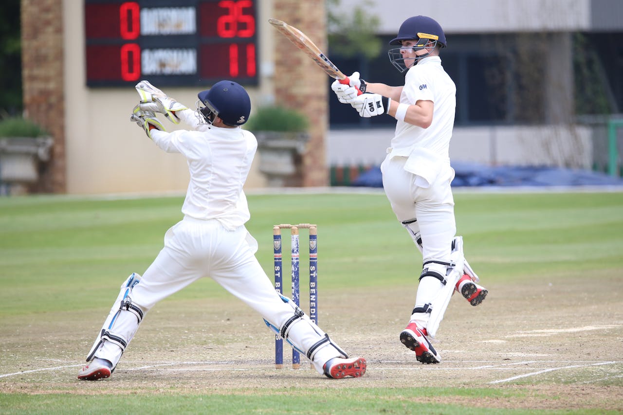 services-02 Dynamic cricket scene with batsman playing a shot and wicketkeeper in action.